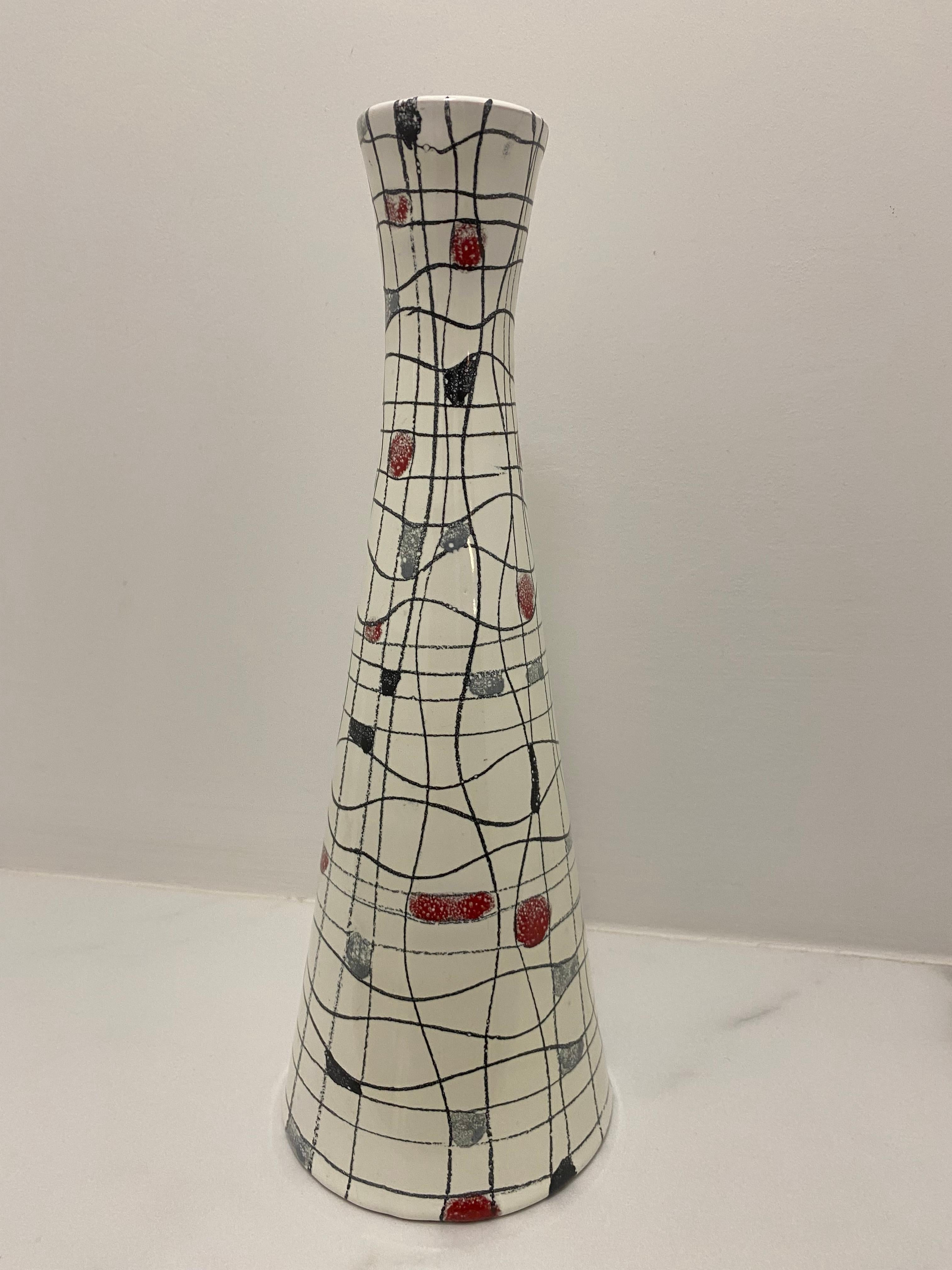 Un vaso in ceramica Bistossi di metà secolo moderno con un disegno a cruciverba stilizzato di linee a ghirigori con quadrati in rosso, giallo, grigio blu e nero su uno sfondo bianco smaltato a trama morbida. 
