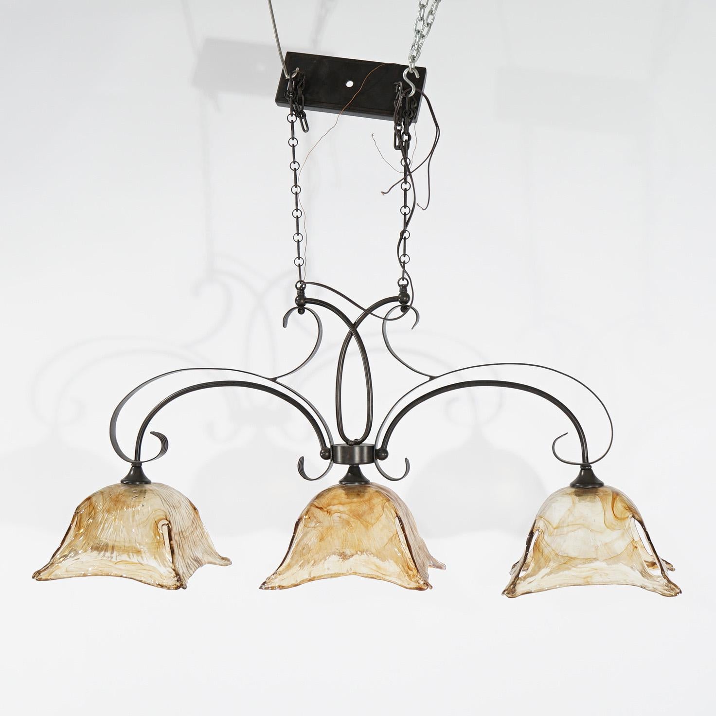 A Mid-Century Modern Venetian chandelier offers wrought iron scroll form frame with three drop lights terminating in Murano style glass shades, 20th century

Measures - 39
