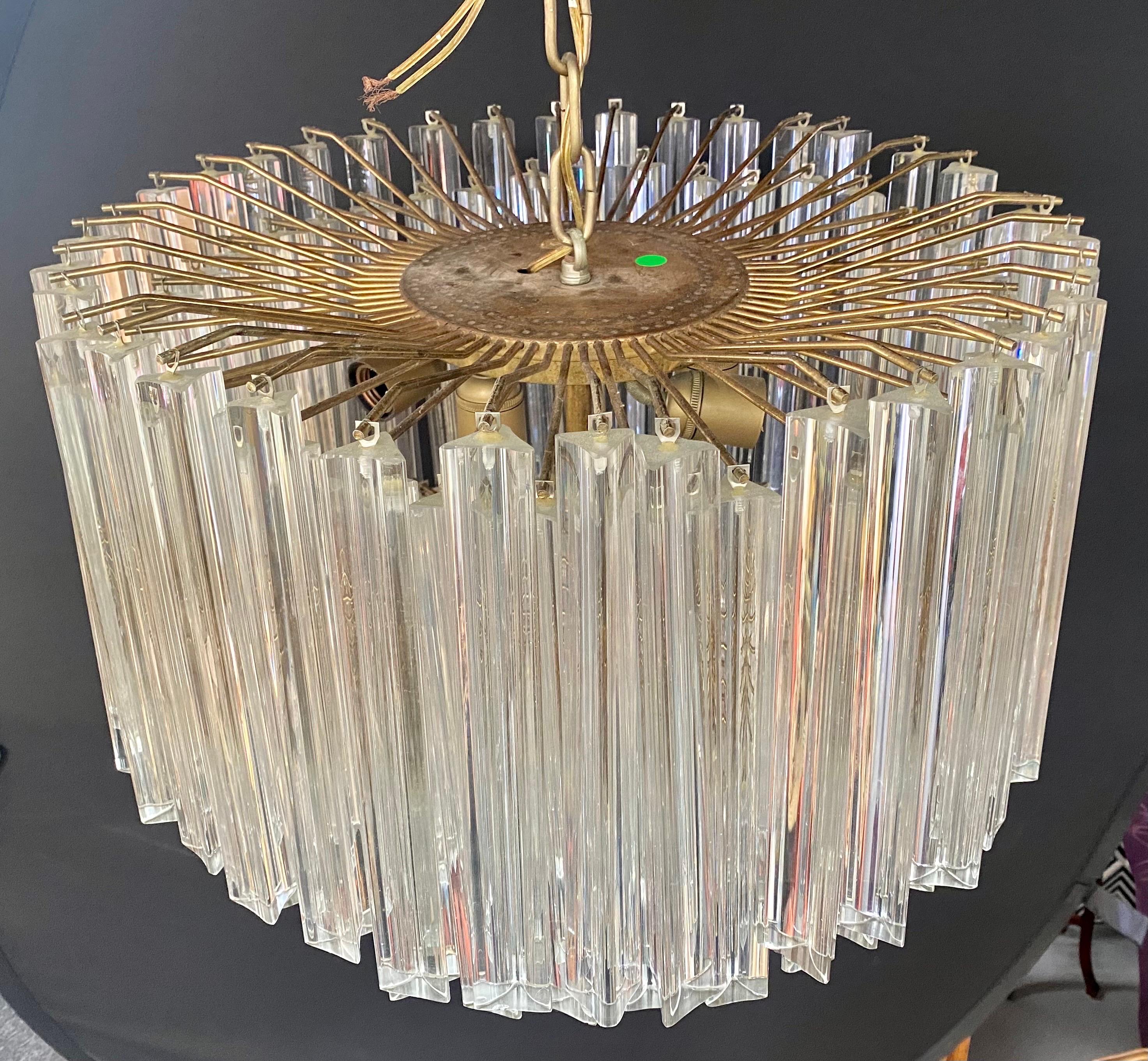 A Mid-Century Modern chandelier by Venini ( Founded 1921 in Milan, Italy by Paolo Venini and Giacomo Cappellin). The oval shaped chandelier is made of individual Murano glass prisms creating a Cascade shape of 7 tiers. The MCM chandelier takes 5