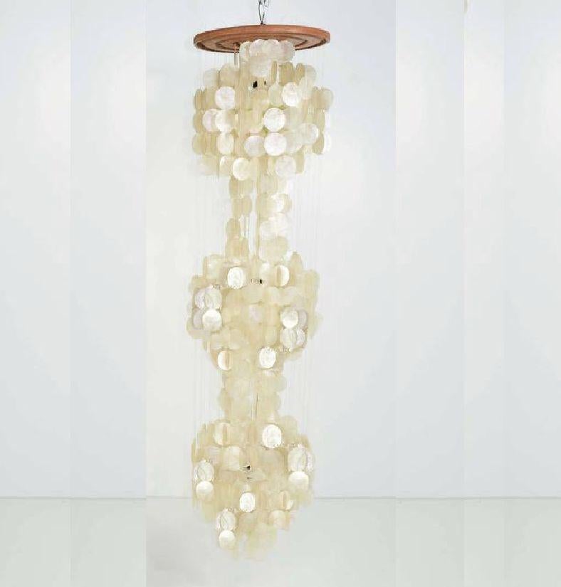 Spectacular three-tiered capiz shell fixture reminiscent of Panton's 1964 '3DM' design. Composed of nylon thread connecting the capiz shells to the top circular wood mount. Cord runs down the middle of the fixture, and each cluster of shells has its