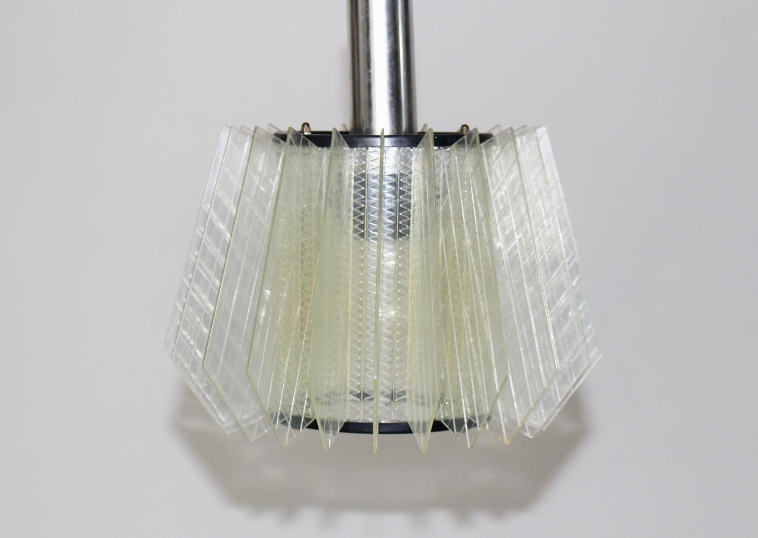 The Mid-Century Modern vintage chandelier features many laminate acrylic glass parts, which are arranged like a fan.
Furthermore the vintage chandelier shows one E 27 socket.
Good vintage condition with signs of age.
Approximate