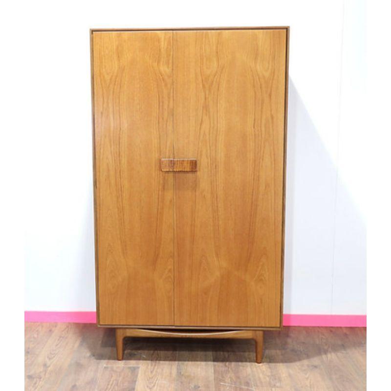 This Stunning Armoire was designed by Ib Kofod-Larsen and manufactured in the UK for G-Plan in the 1960s. It is made from African teak and is classed as a Gentlemens wardrobe due to the drawers and shelves inside. This armoire is in great vintage