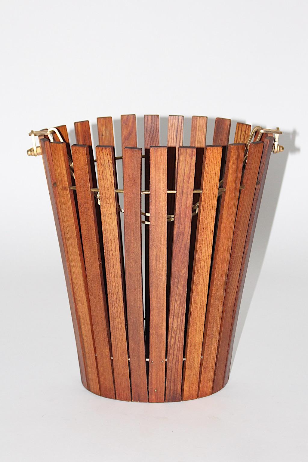 Mid-Century Modern vintage paper basket or basket from ash and brass in conical shape Austria 1960s.
The wonderful paper basket features slats from ash wood which are connected with brass rings.
While a brass chain as decoration underlines the