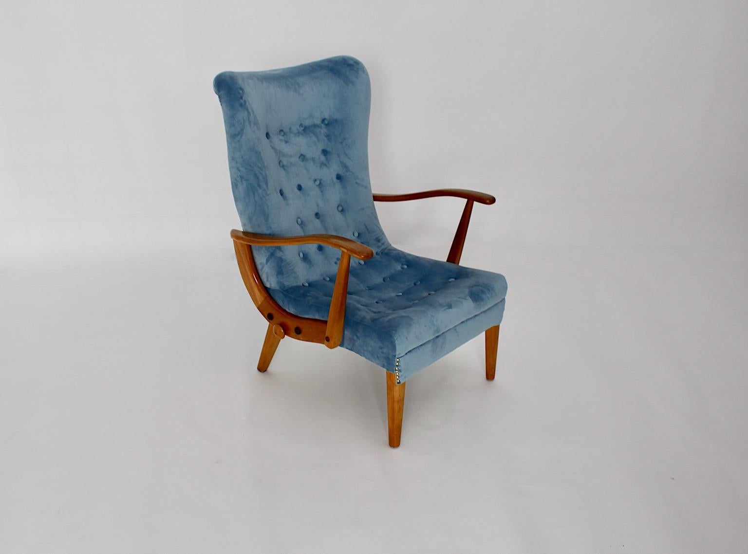 Mid-Century Modern Vintage blauer Sessel Lounge Chairs aus Buche entworfen und hergestellt Österreich 1950er Jahren.
Während die Sitzschale neu mit himmelblauem Samtstoff bezogen ist, weist das Buchenholzgestell einen schönen honigbraunen Ton