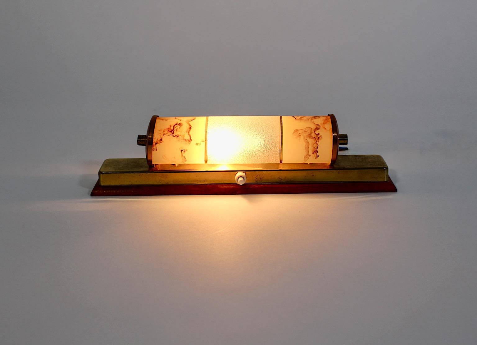 Mid Century Modern vintage sconce or wall light from beech, brass, copper and glass in circular shape 1940s, Austria.
An amazing sconce or wall light from brass, copper and beech in soft pastel color tones with a glass shade in circular shape from