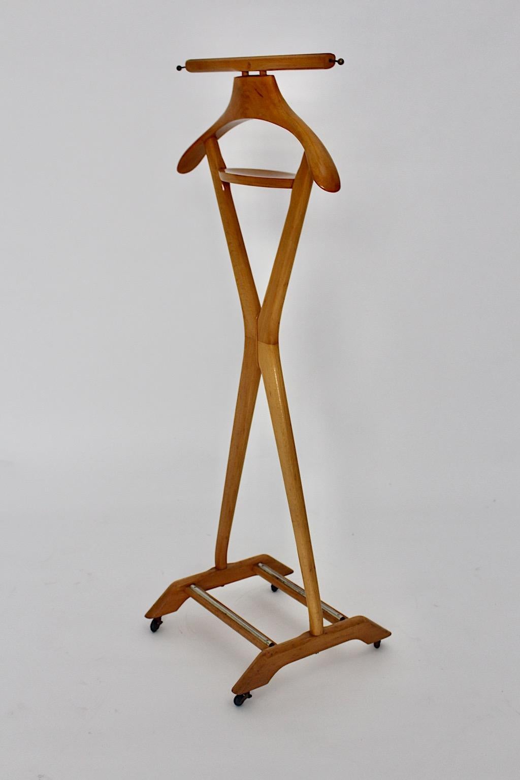 Mid-Century Modern vintage valet or coat rack from solid beech Ico & Luisa Parisi Style 1950s Italy.
The valet shows wonderful design features like a reduced x like form and brass details.
Four wheels and one tray for your bric-a brac.
Labeled