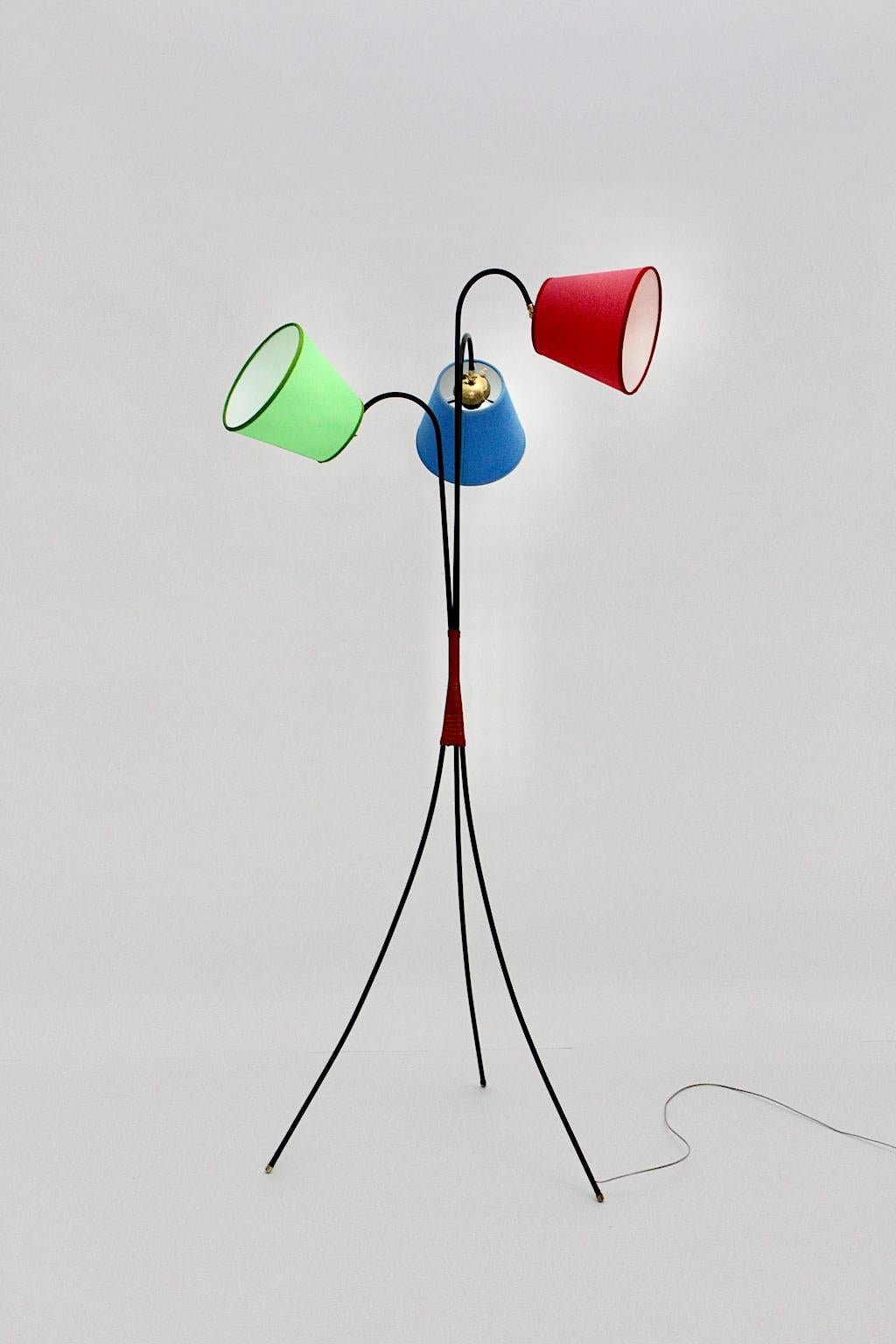 Mid-Century Modern vintage black metal trilegged floor lamp 1950s Vienna was made of black coated metal wire with red plastic strings, which waist and connect the black metal feet. Furthermore the renewed lampshades, which are recreated like the