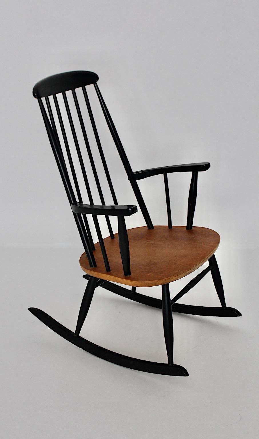 Chaise à bascule vintage en hêtre et teck dans les tons noirs et bruns par Ilmari Tapiovaara pour Asko Finlande, années 1950.
Une magnifique chaise à bascule en hêtre et en teck du designer finlandais
Ilmari Tapiovaara pour Asko 1950s. Je tiens à