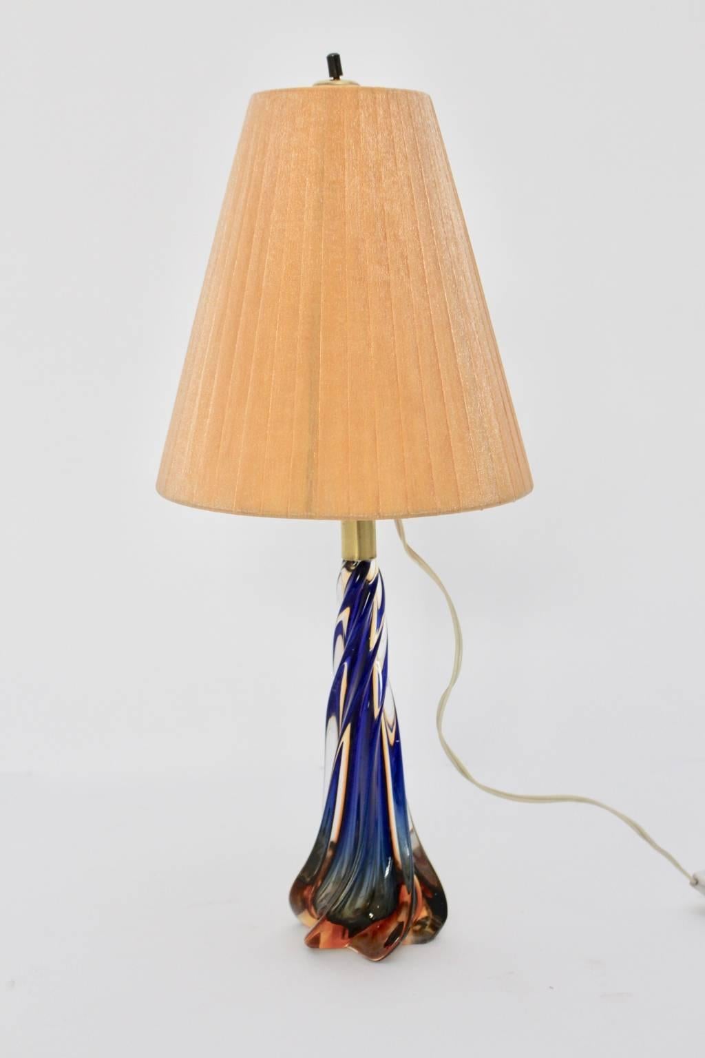 Mid-Century Modern vintage blue and orange Murano glass table lamp, which shows turned glass base and brass details. This delicate piece was designed and made out in Murano, Venice, Italy in the 1950s.
The cute and beautiful glass base shows an
