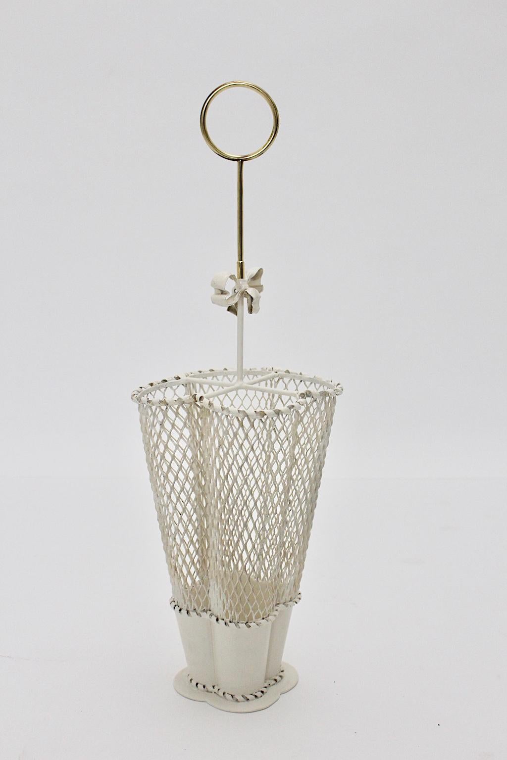 The charming vintage brass and white metal umbrella stand was designed by Mathieu Mategot and executed by Atelier Mategot, 1950s.
The umbrella stand was made of perforated white lacquered metal and shows also a brass handle and a nice bow.
Very