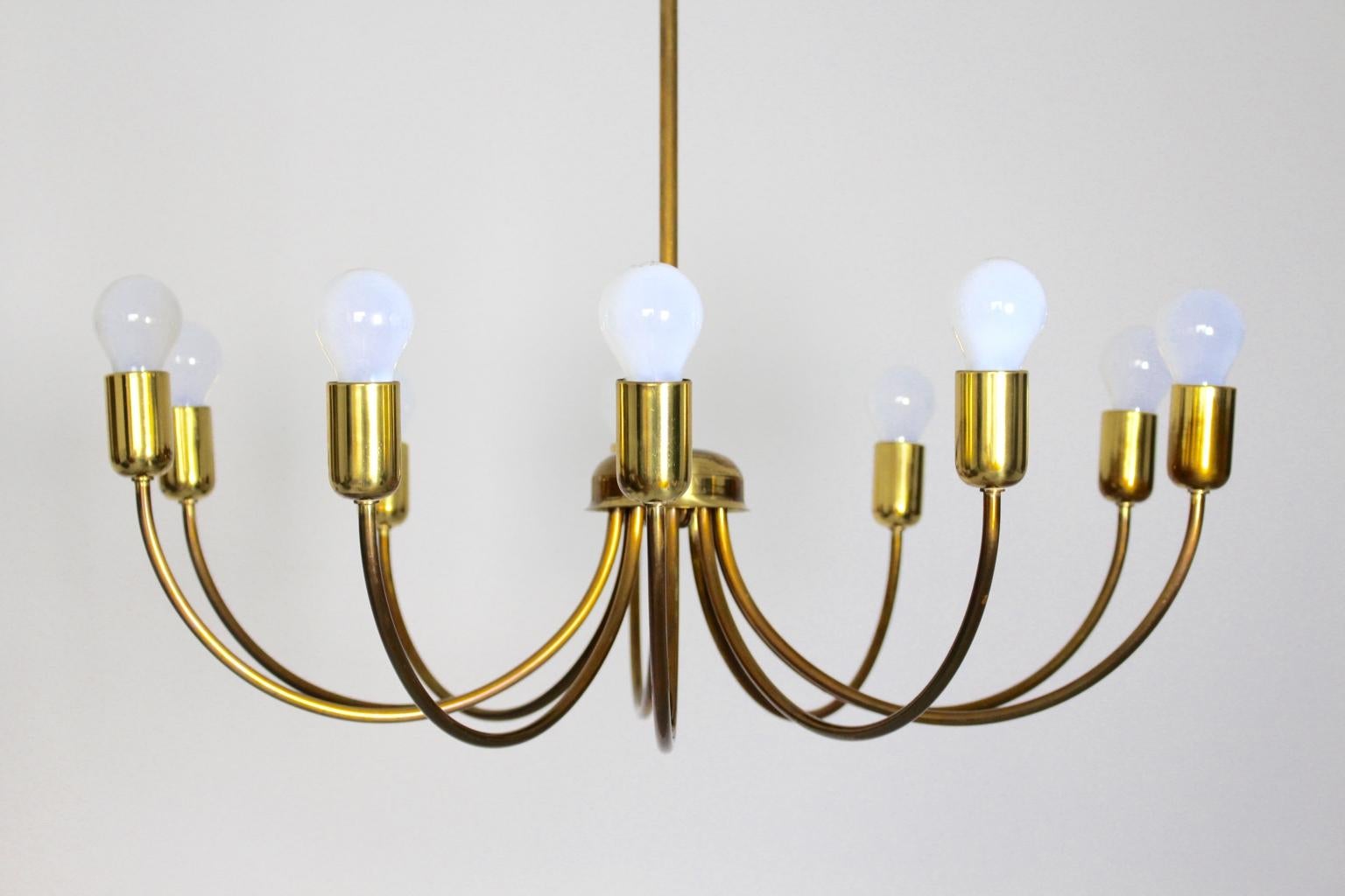 The mid century modern vintage brass chandelier with curved 10 arms shows a wonderful brass patina on the surface and features the possibility to minimize the light blaze from 10 bulbs to 5 bulbs. 10 sockets for E 27
The vintage condition is very