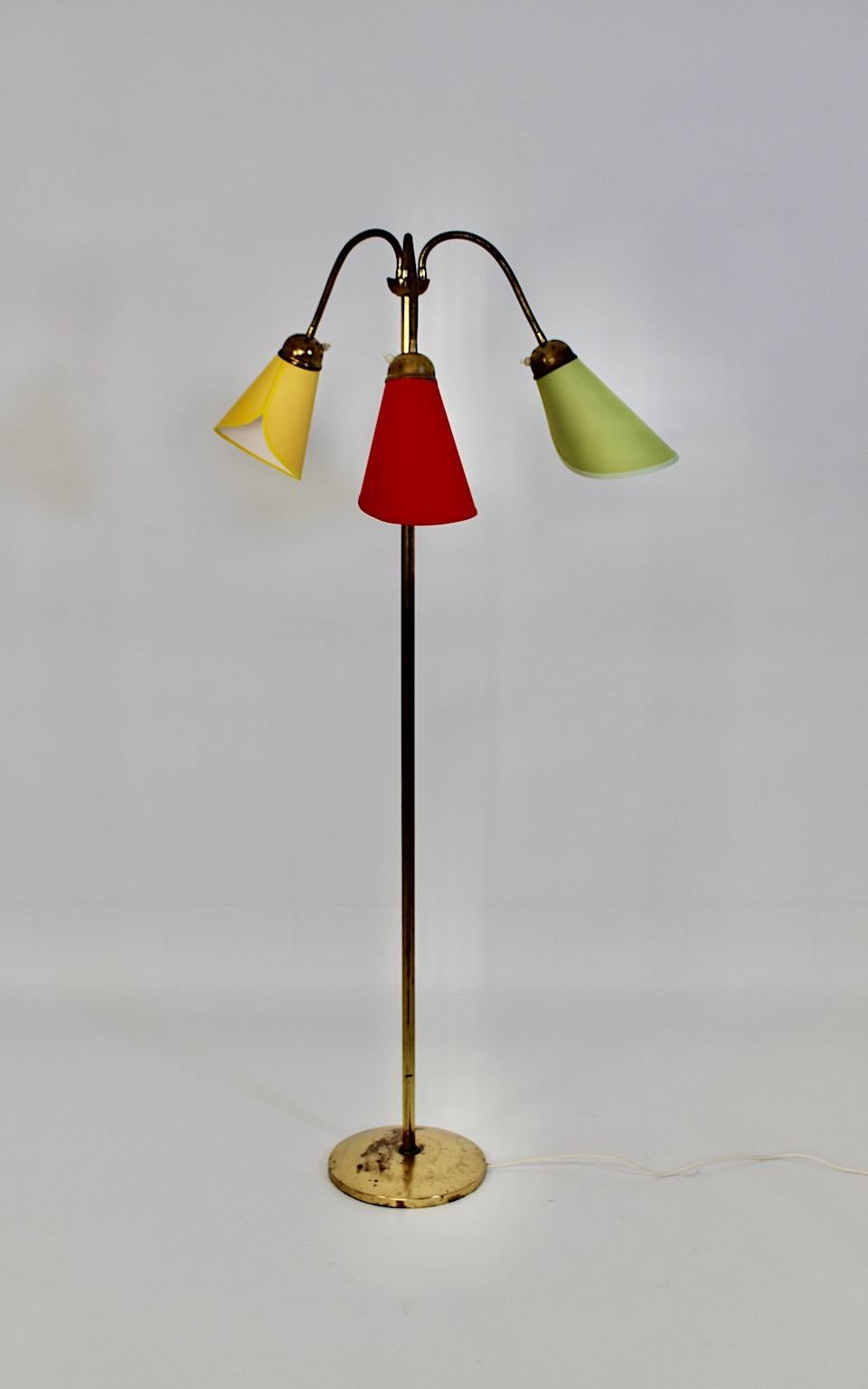 Mid Century Modern vintage brass floor lamp with colorful lamp shades 1950s Austria.
A stunning floor lamp from brass with three flexible arms topped with hand made lamp shades in cone shape with a circular base.
Each arm is separately to switch and