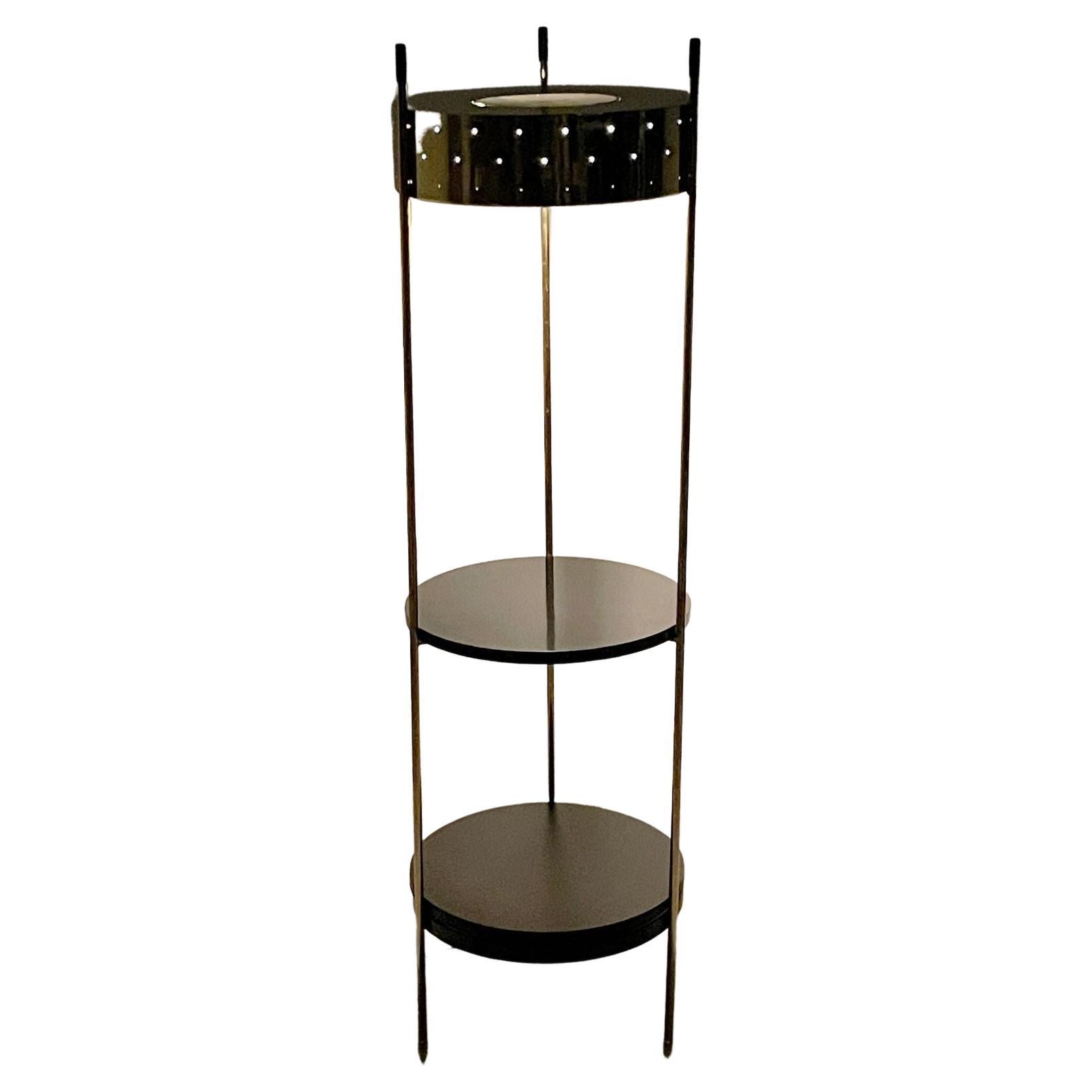 Vintage Mid Century Modern Laurel Brass Floor Lamp with Shelves 1960s

Incredible brass floor lamp etagere by Laurel circa 1960s
Pierced brass cylinder shade atop two lower round shelves
Interchangeable lower shelf and black metal