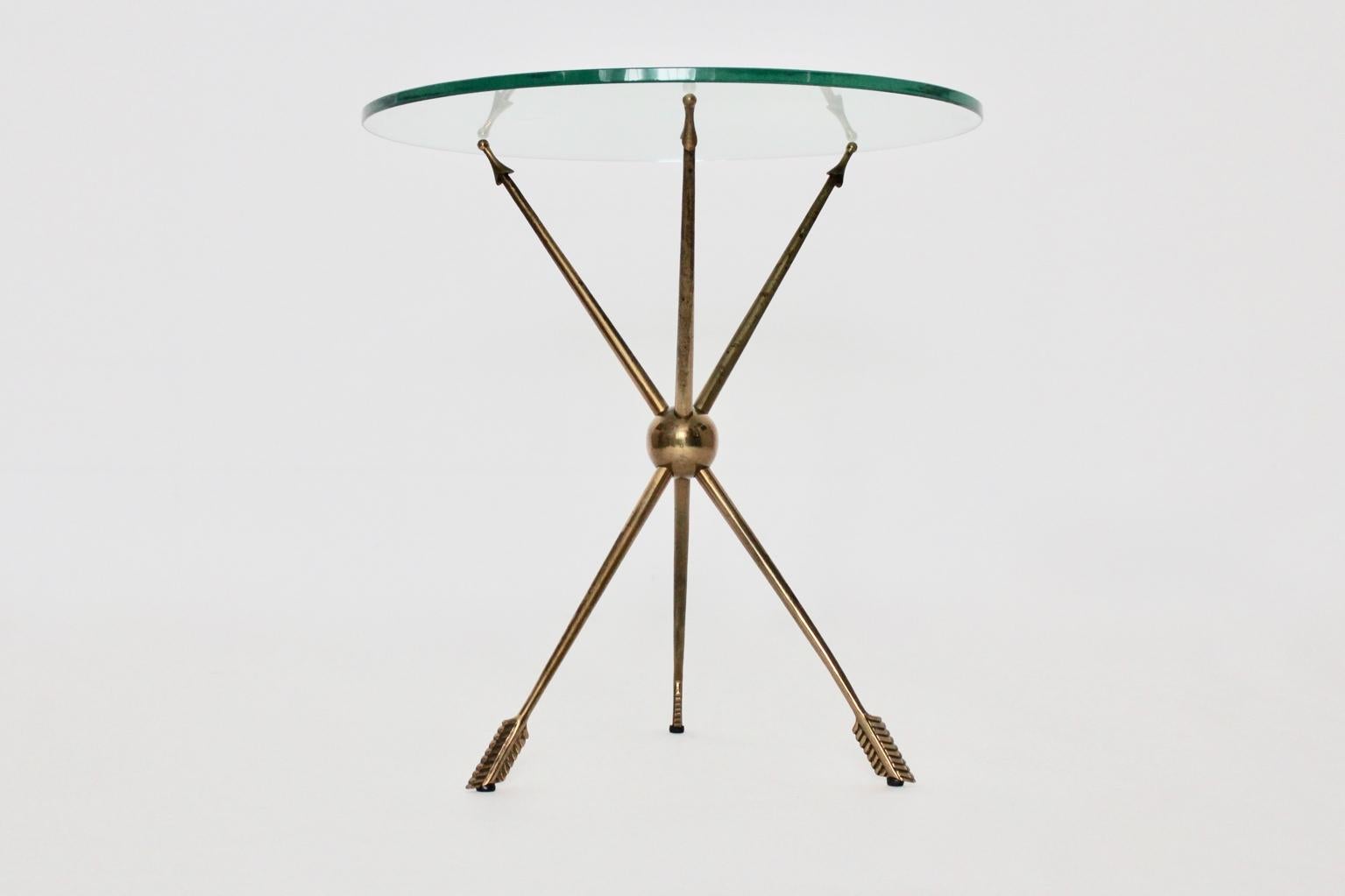 We offer a gorgeous mid century modern circular top-quality vintage side table or occasional table, Italy 1950s with brass and glass construction.
The vintage side table features three brass arrows with one brass ball holding the clear glass top.