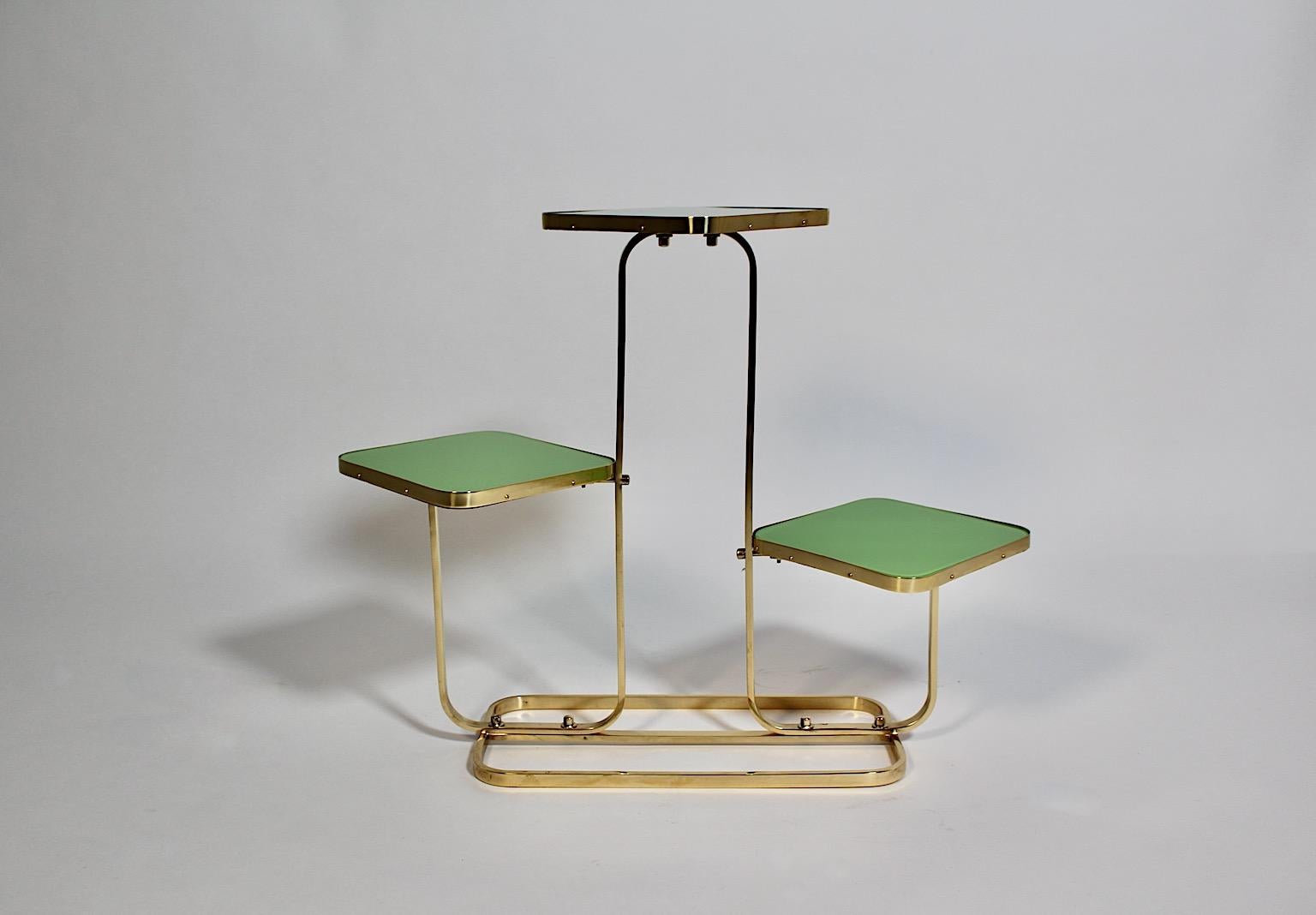 Mid-Century Modern vintage flower stand from brass and squared green glass plates 1950s Austria.
An amazing and elegant flower stand from brass and three squared plates covered with grass green glass. The squared plates are underlaid with beechwood