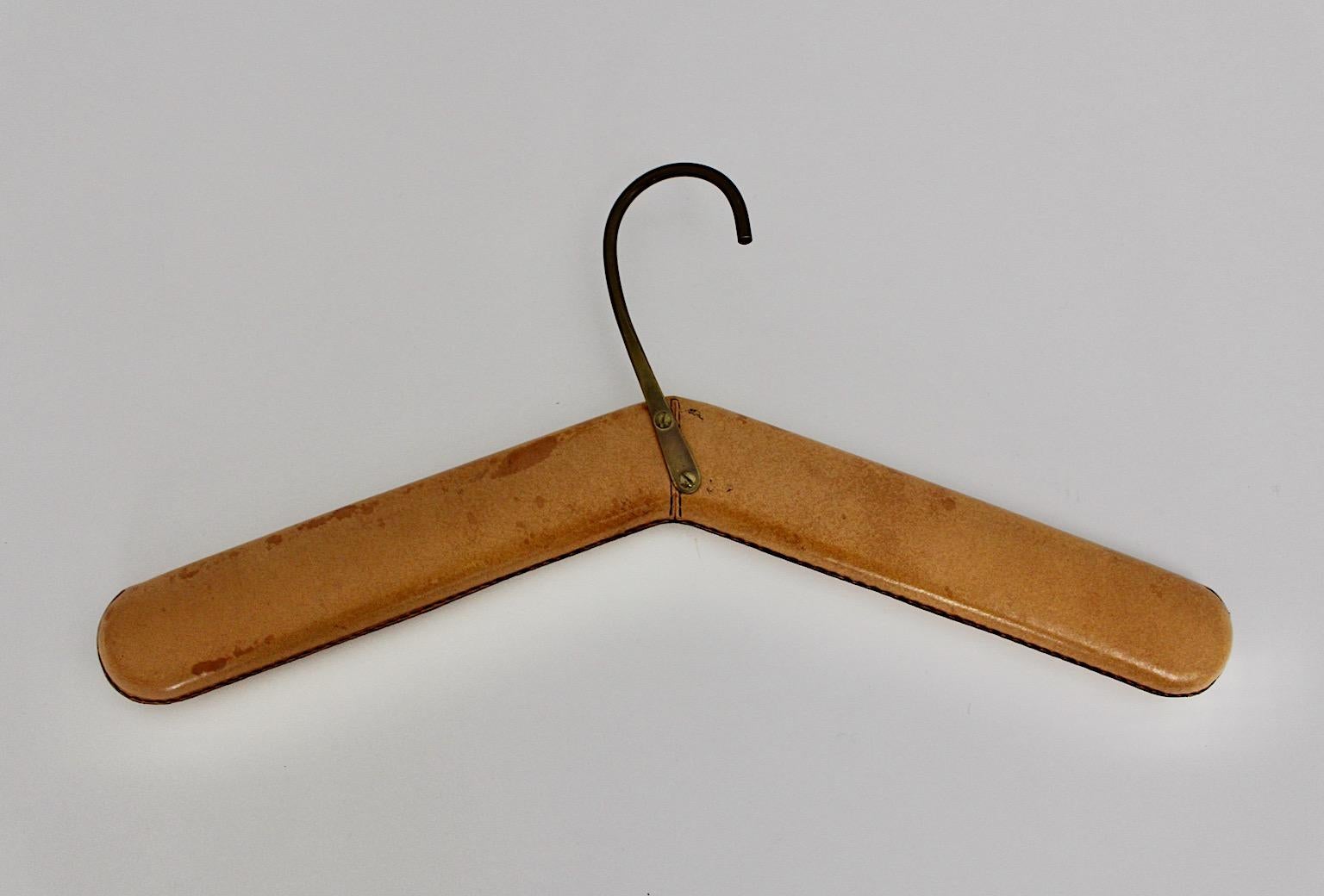 Mid-Century Modern vintage leather coat hook designed and executed by Carl Auböck workshop 1960 Vienna, which shows a beautiful hand stitched cognac patinated leather surface with solid brass hook.
The coat hook features real personality and is