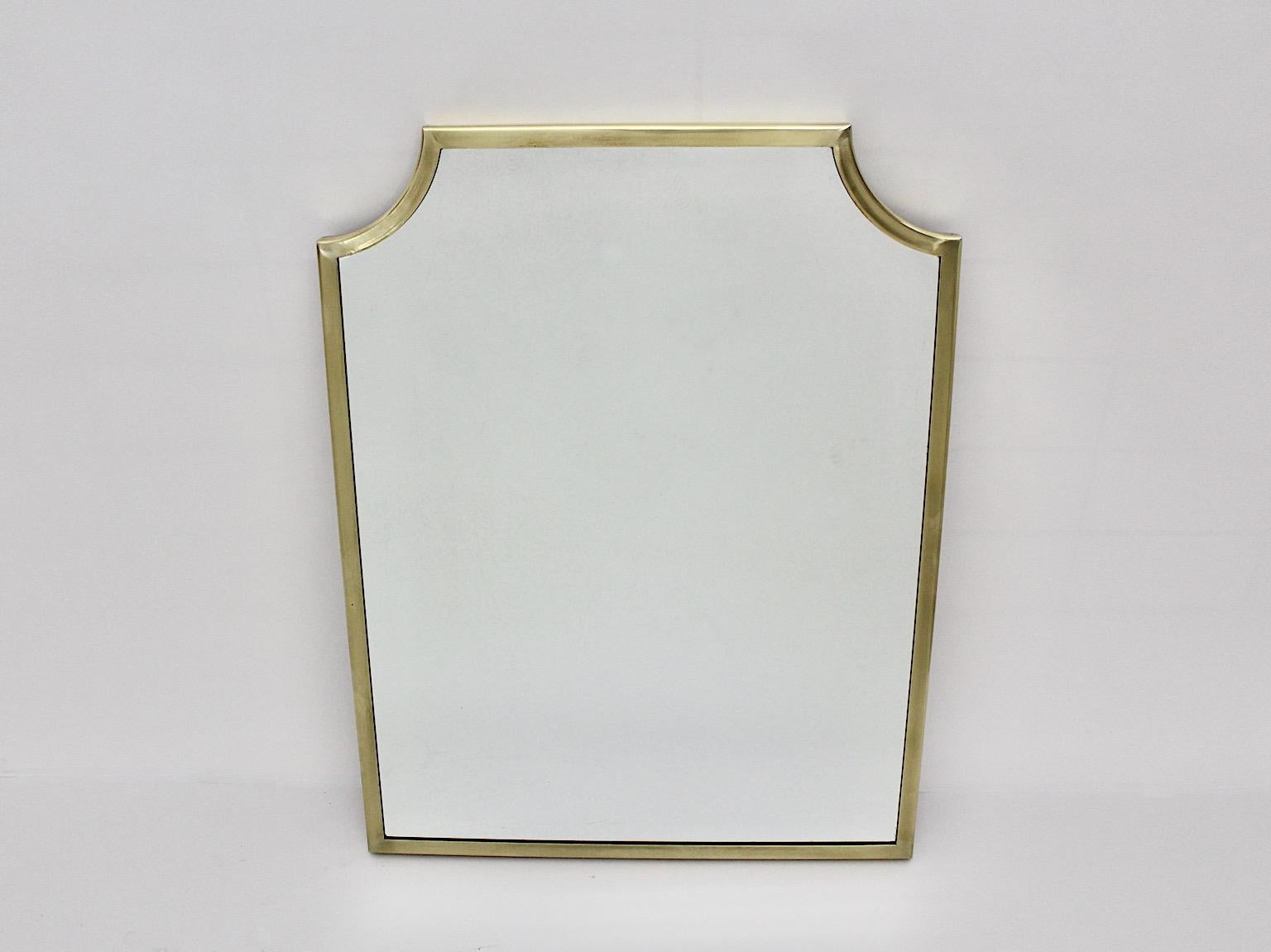 Mid-Century Modern vintage wall mirror from brass in rectangular form 1950s Italy.
A sophisticated wall mirror with brass handmade frame in rare rectangular form with slightly curved corners in a luscious golden tone. 
While the brass frame shows