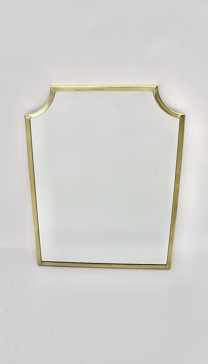 Mid-Century Modern vintage wall mirror from brass in rectangular form 1950s Italy.
A sophisticated wall mirror with a brass frame in rare rectangular form with slightly curved corners in a luscious golden tone. 
While the brass frame shows fine