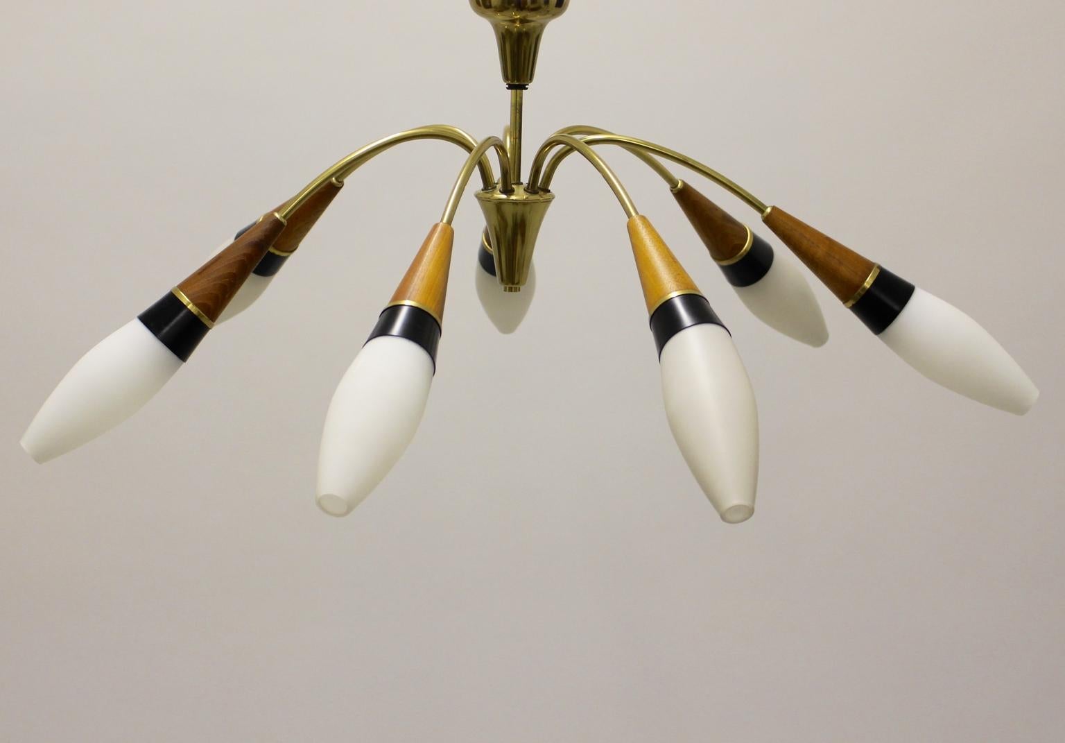 This flush mount by Rupert Nikoll was designed and made circa 1950 in Austria.
The elegant and simple design of this flush mount features seven opaline oval shaped glass shades. Also the frame shows walnut parts and brass. Seven E 14 sockets
The