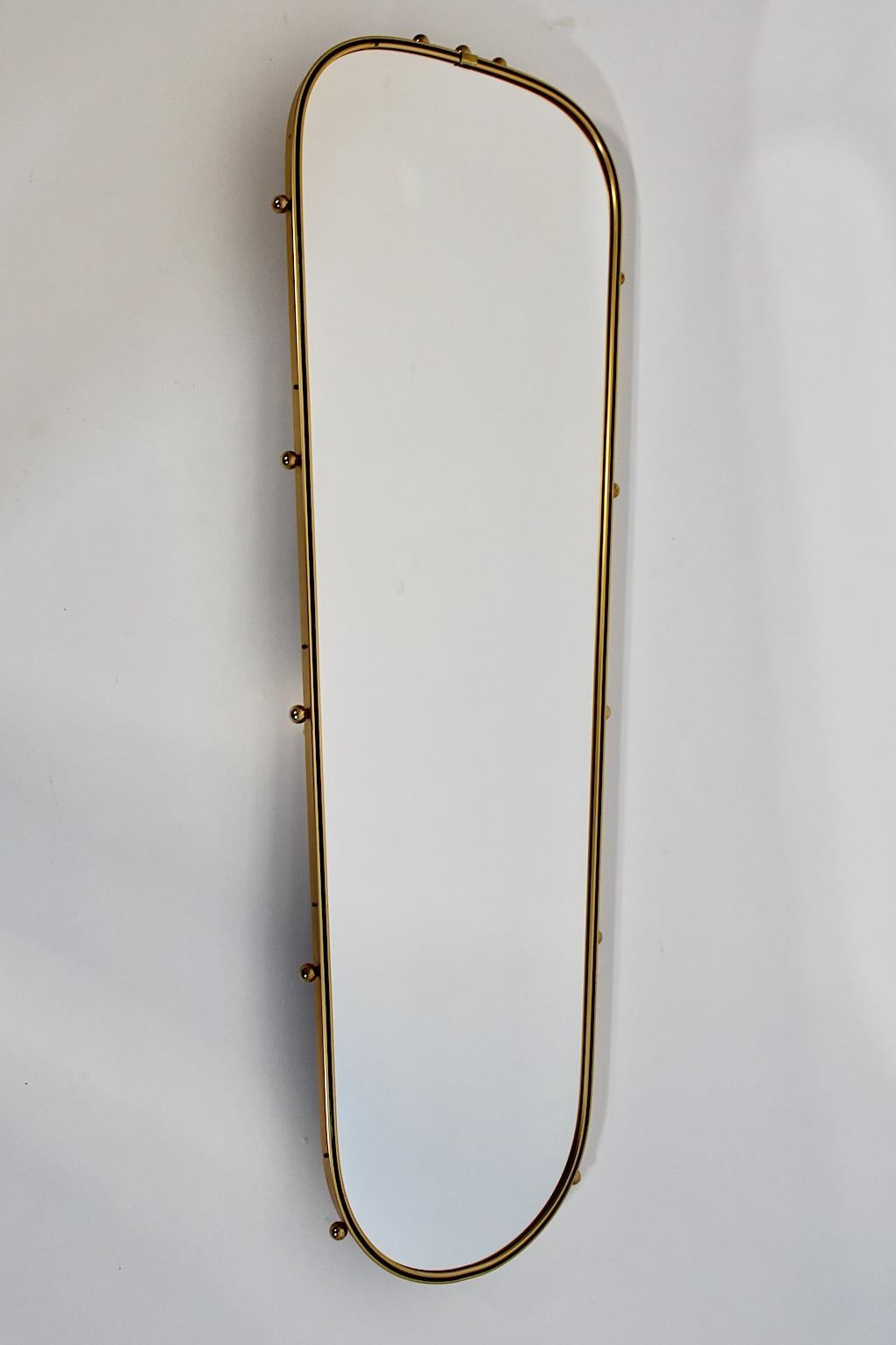 Specchio da parete o a figura intera in metallo ottonato, plastica nera e sfere in ottone, anni '60.
Uno specchio da parete sorprendente e gioioso, questo specchio da terra dalla sofisticata forma ovale con un arredamento sorprendente.
Questo