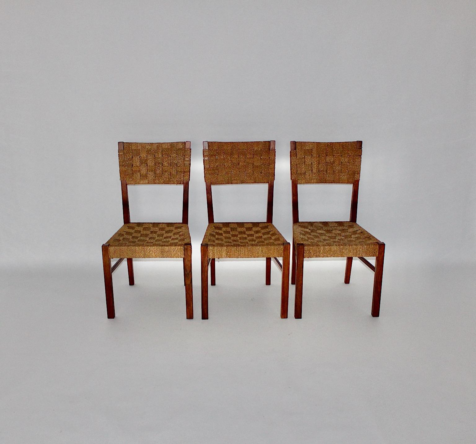 Mid-Century Modern three vintage dining chairs or chairs from walnut and sisal cords in brown color tone Austria 1950s.
Three minimalistic organic dining chairs or chairs feature solid walnut frame in beautiful brown color with wrapped sisal cord