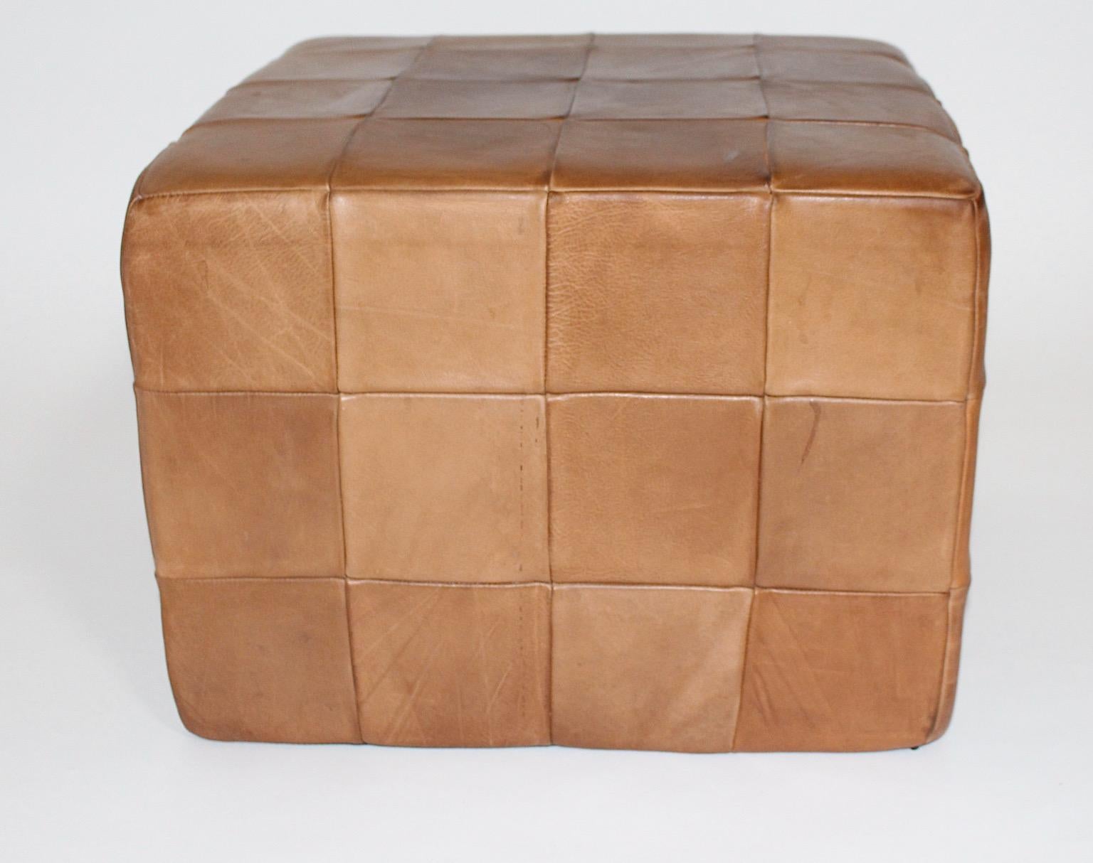 Modernist organic vintage leather stool or ottoman cubus like from stitched patchwork leather in cognac brown color tone by deSede 1970s Switzerland.
Throughout the different brown color shades this high quality vintage cubus stool is a stunning