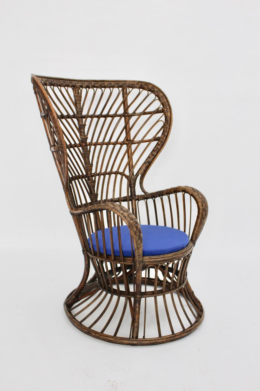 Mid Century Modern vintage armchair or wingback chair from stained rattan by
Lio Carminati style Gio Ponti designed circa 1948 Italy and executed 1950s.
While the freestanding armchair shows a high wingback for relaxing and reading, the seat has a