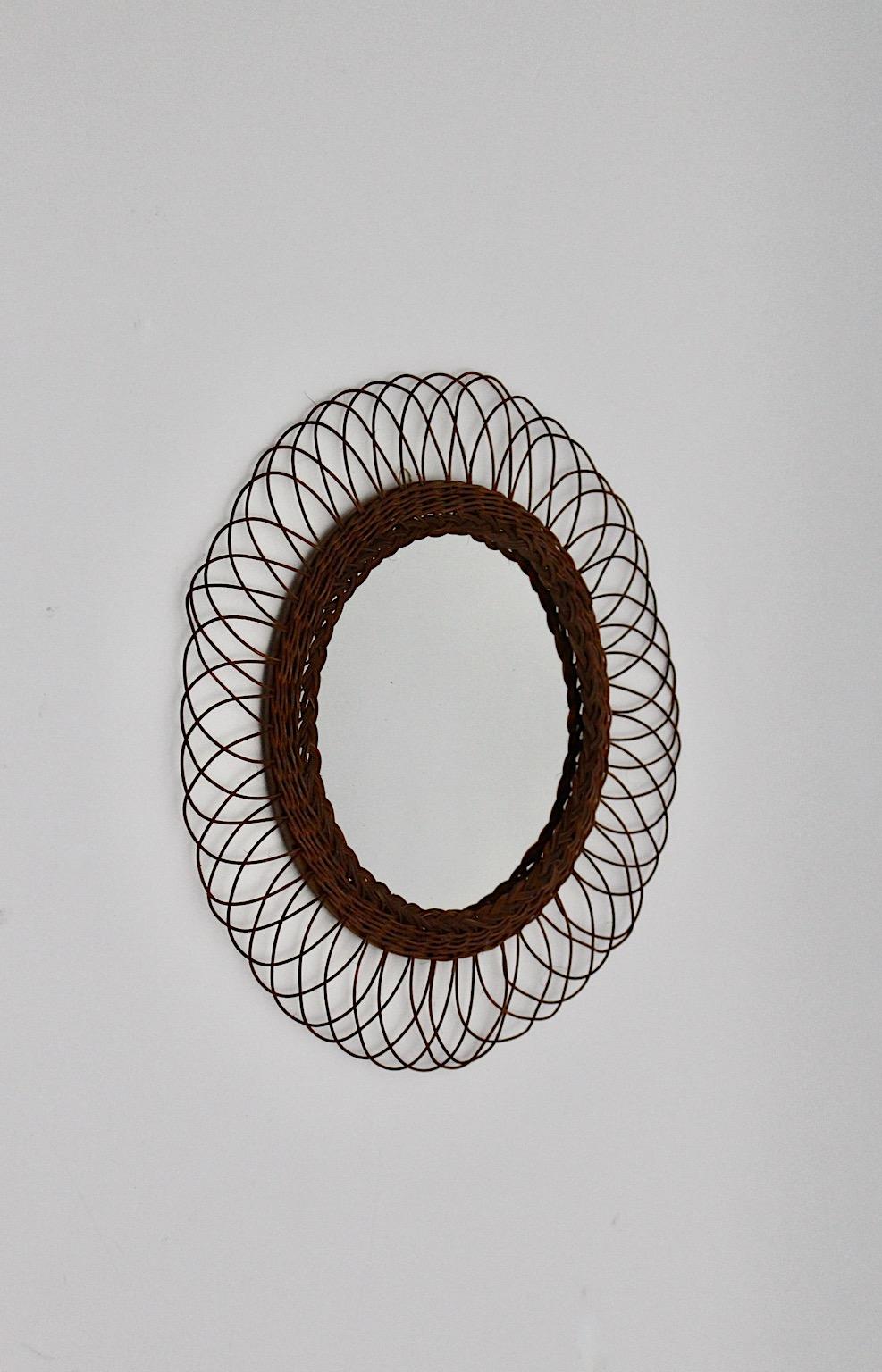 Mid-Century Modern vintage brown wall mirror circular like from willow, 1960s Austria.
A stunning and delicate circular like wall mirror framed with braided willow and slightly curved loops like sunbursts or blossom leaves.
This wall mirror could