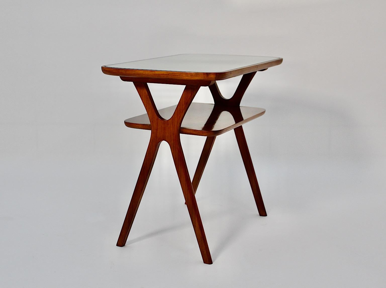 Table d'appoint ou table de nuit vintage Mid Century Modern style Ico Parisi, 1950s Italy.
Une superbe table d'appoint dans le style d'Ico Parisi en construction X surmontée d'une plaque de miroir incrustée.
D'une chaleur et d'une profondeur