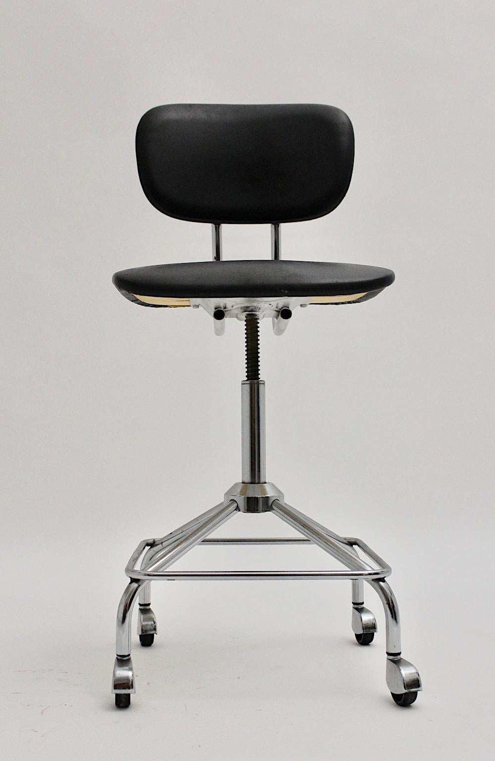 Mid-Century Modern vintage chromed desk chair or office chair from black faux leather and chromed metal manufactured 1950s Germany, style Egon Eiermann.
The vintage desk chair shows swiveling and adjustable features. Adjustable back to height and