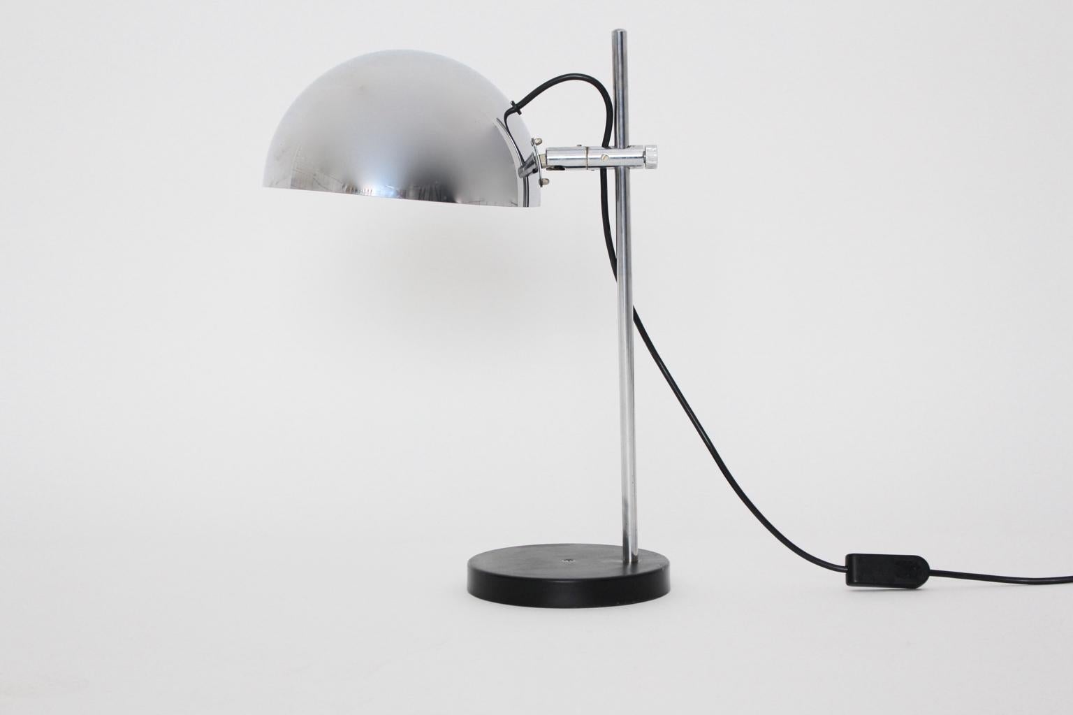 The pivoting and adjustable table lamp shows a black lacquered stem and chromed steel. Also the table lamp features one socket E 27 and an on/off switch.
The vintage condition is very good.
Approximate measures:
Diameter 33 cm
Height 56 cm.