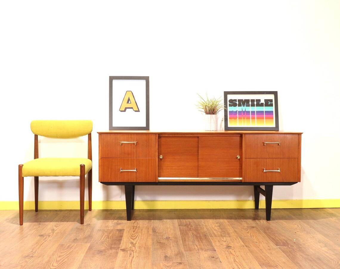 A stylish mid-century low credenza by British furniture maker, Austinsuite. Although slightly smaller than some credenza it still has plenty of storage space. This credenza has a great grain to the wood and would look wonderful in any