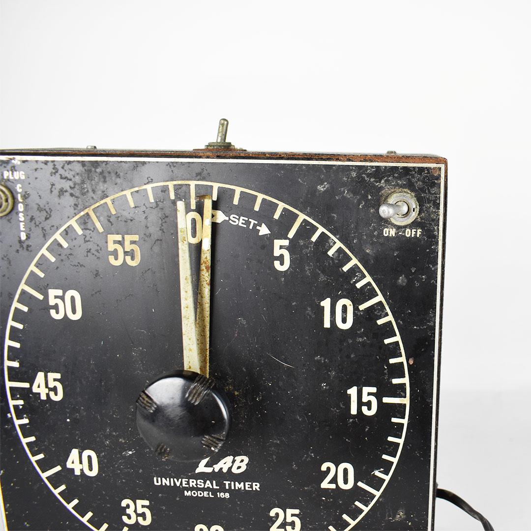 Vintage square black darkroom photography timer. Created from black metal, it features an on/off switch, outlet plug, this would have been used in a darkroom when developing photos in the mid-20th century. A fantastic vintage piece that would make a