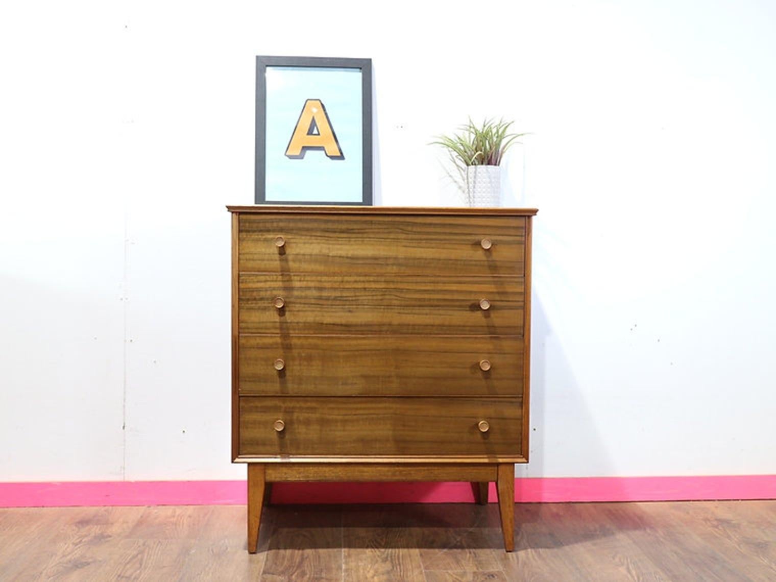 Discover the elegance of mid-century design with our stunning dresser by Alfred Cox, available exclusively at Mid Century Traders. This gorgeous dresser, made from exquisite walnut veneer, showcases a beautiful wood grain that adds a touch of