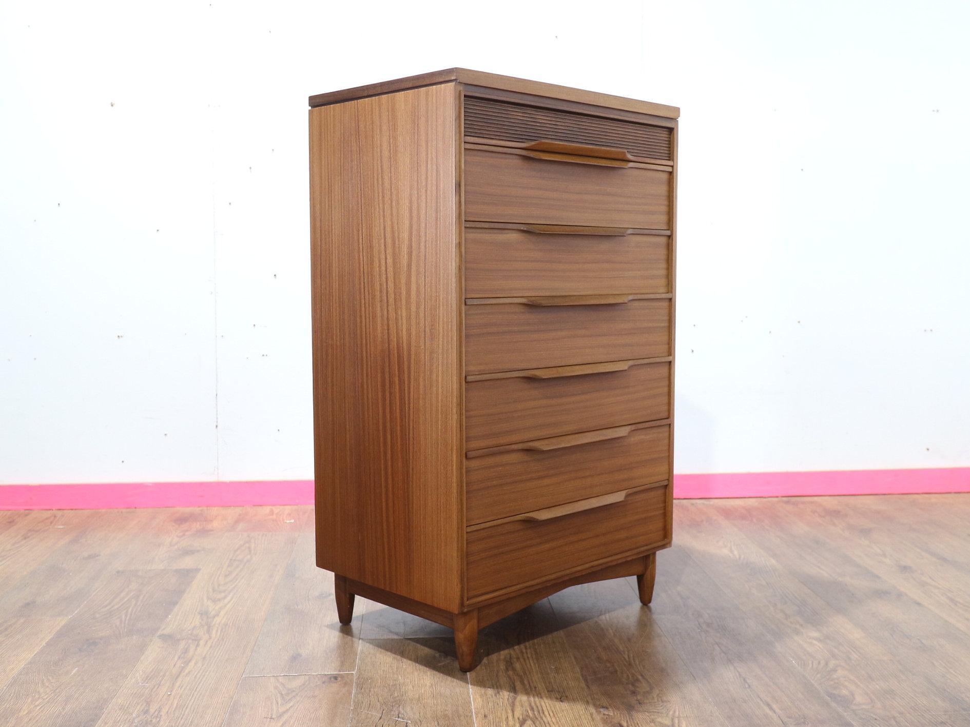 Migliora il tuo spazio abitativo con il fantastico comò alto Mid Century Modern del produttore di mobili britannico White & Newton. Questo pezzo notevole offre un'ottima capacità di contenimento ed è ornato da bellissime maniglie, che mettono in