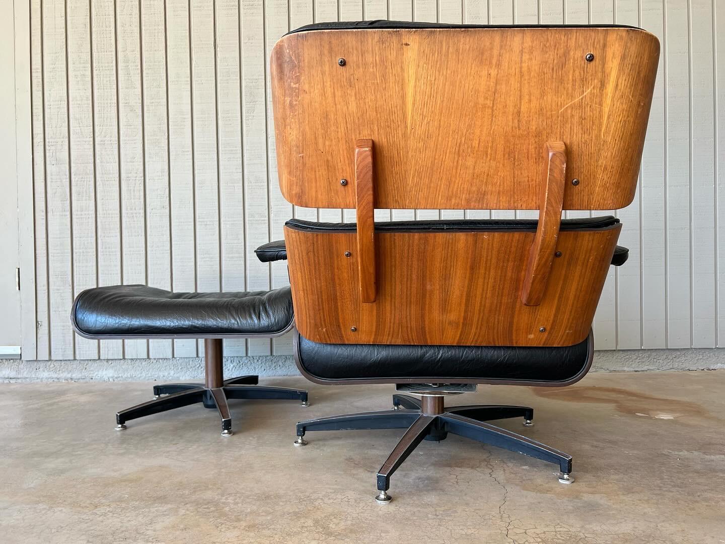 1970s vintage Charlton Company, Inc. mid century modern lounge chair and ottoman in walnut with original black vinyl. The chair swivels, tilts and rocks with its original sturdy Lester mechanism. The ottoman swivels. The extra bounce and rotating