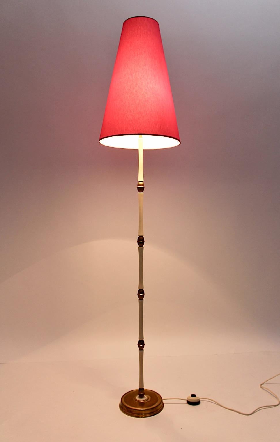 Lampada da terra vintage in ottone e bianco degli anni '40, originale e sorprendente, composta da ottone, metallo e legno di faggio laccato bianco.
Inoltre presenta un paralume rinnovato rivestito in tessuto rosa fragola.
La forma del nuovo paralume