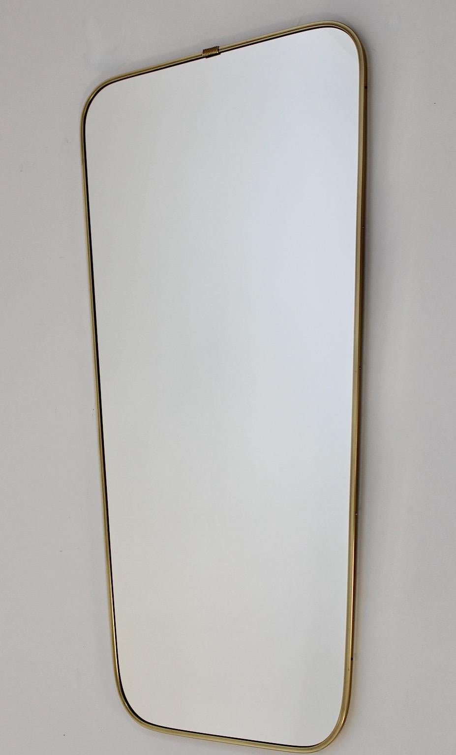 Mid Century Modern Modernist vintage brass full length mirror floor mirror 1950s Italy.
A stunning modernist sleek vintage floor mirror with a subtle brass golden frame
in a slightly conical shape.
This full length mirror from the 1950s shows a warm