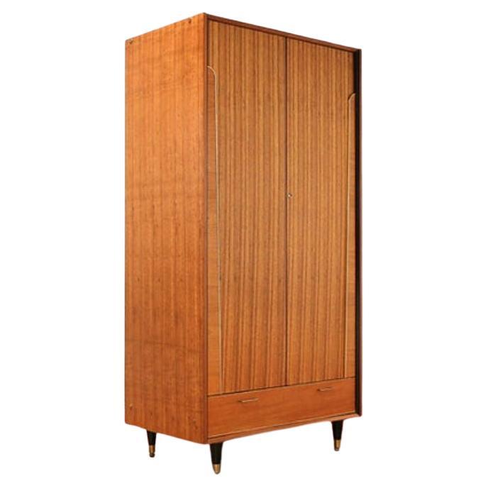 A stunning mid century armoire by British furniture maker, Beautility. 

This fabulous armoire offers great storage whilst looking fantastic, with both a hanging section as well as shelves then a lower drawers this wardrobe was classed as a
