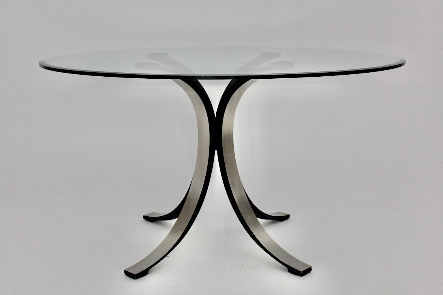 A Mid-Century Modern vintage dining table, which was designed by Osvaldo Borsani for Tecno, Italy, 1963.
The base with curved legs was made of black lacquered cast aluminum with brushed nirosta.
Labelled by Tecno.
Topped with a round clear glass