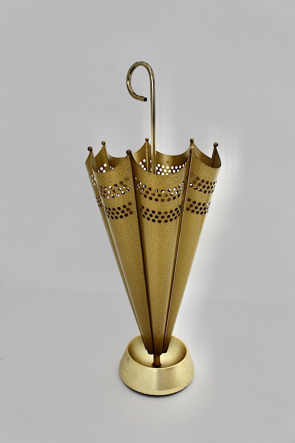 Mid-Century Modern vintage umbrella stand from golden metal and brass 1950s Austria.
A stunning umbrella like umbrella stand in umbrella shape with brass handle and a perforated body from hammered finish and lacquered surface in golden color.
This