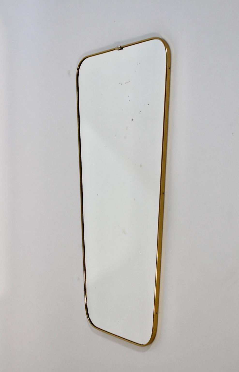 Mid Century Modern Vintage goldenen Metall voller Länge Spiegel oder Boden Spiegel, 1950er Jahre Österreich.
Ein erstaunlicher Spiegel in voller Länge oder Bodenspiegel mit leicht gewölbten Ecken in rechteckiger Form mit einem kleinen Dekor an der