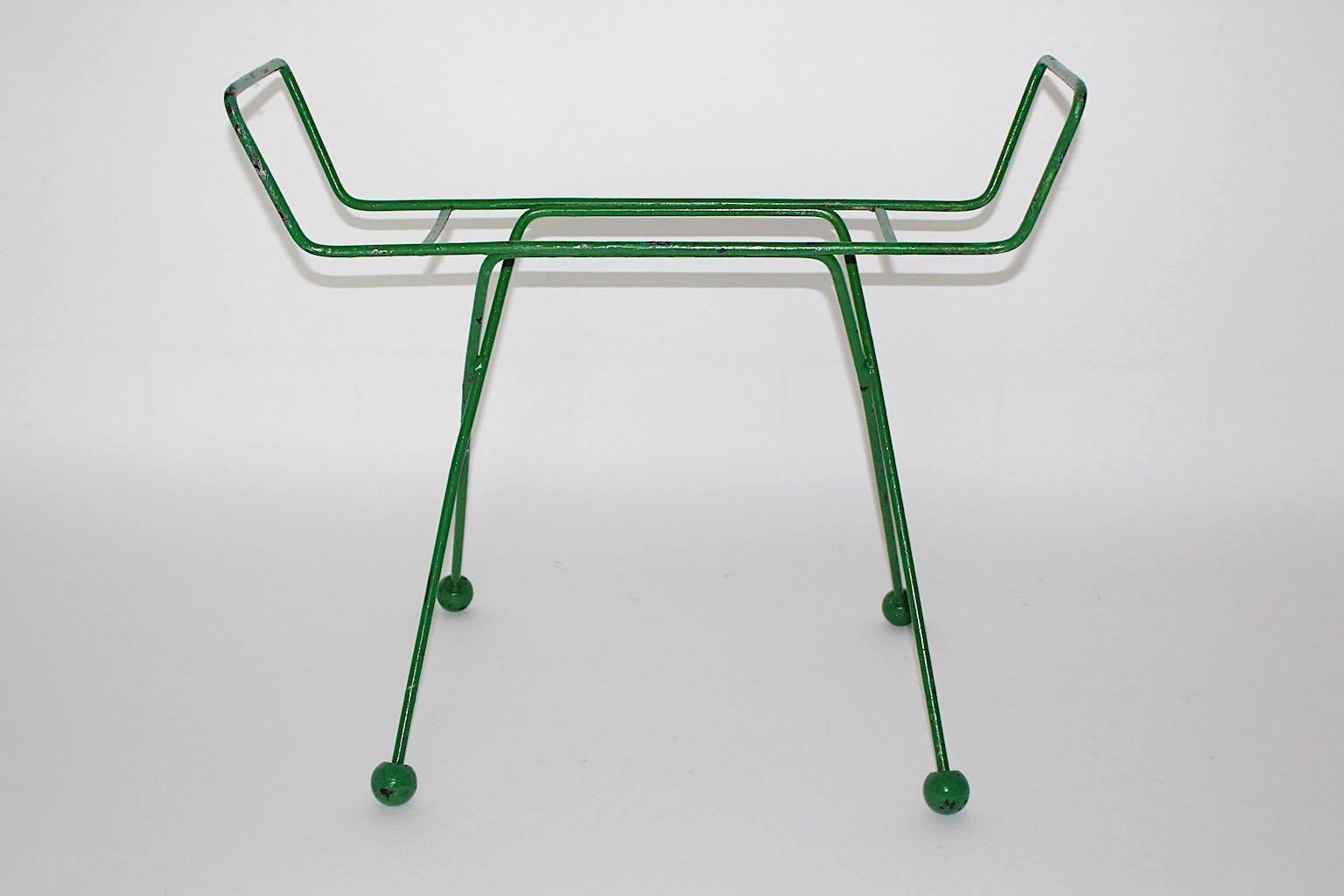 Mid Century Modern vintage luggage rack or rack for suitcases from metal and wood in fresh green color 1950s France. 
A fabulous construction from green lacquered metal with four lollipop - like wooden balls at the end of the legs, could provide a