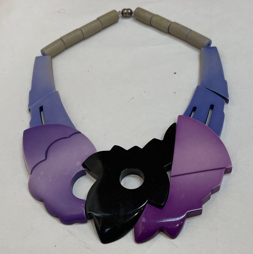 Beautiful Galalith Art Deco Revival 1970s Modernist Necklace. In Striking Rich Mauve, Black and Blue Abstract Geometric panels. Signed ISADORA PARIS on reverse.  Necklace measures approx. 17” long and panels 12” long Magnetic clasp. Galalith is a