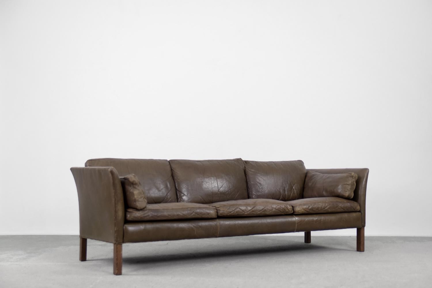 Dieses 3-sitzige Ledersofa Cromwell wurde in den 1960er Jahren von Arne Norell entworfen. Es ist ein zeitloses Design und heute noch genauso beliebt wie vor 60 Jahren, als es auf den Markt kam. Das Sofa ist mit hochwertigem Naturleder in erdigen