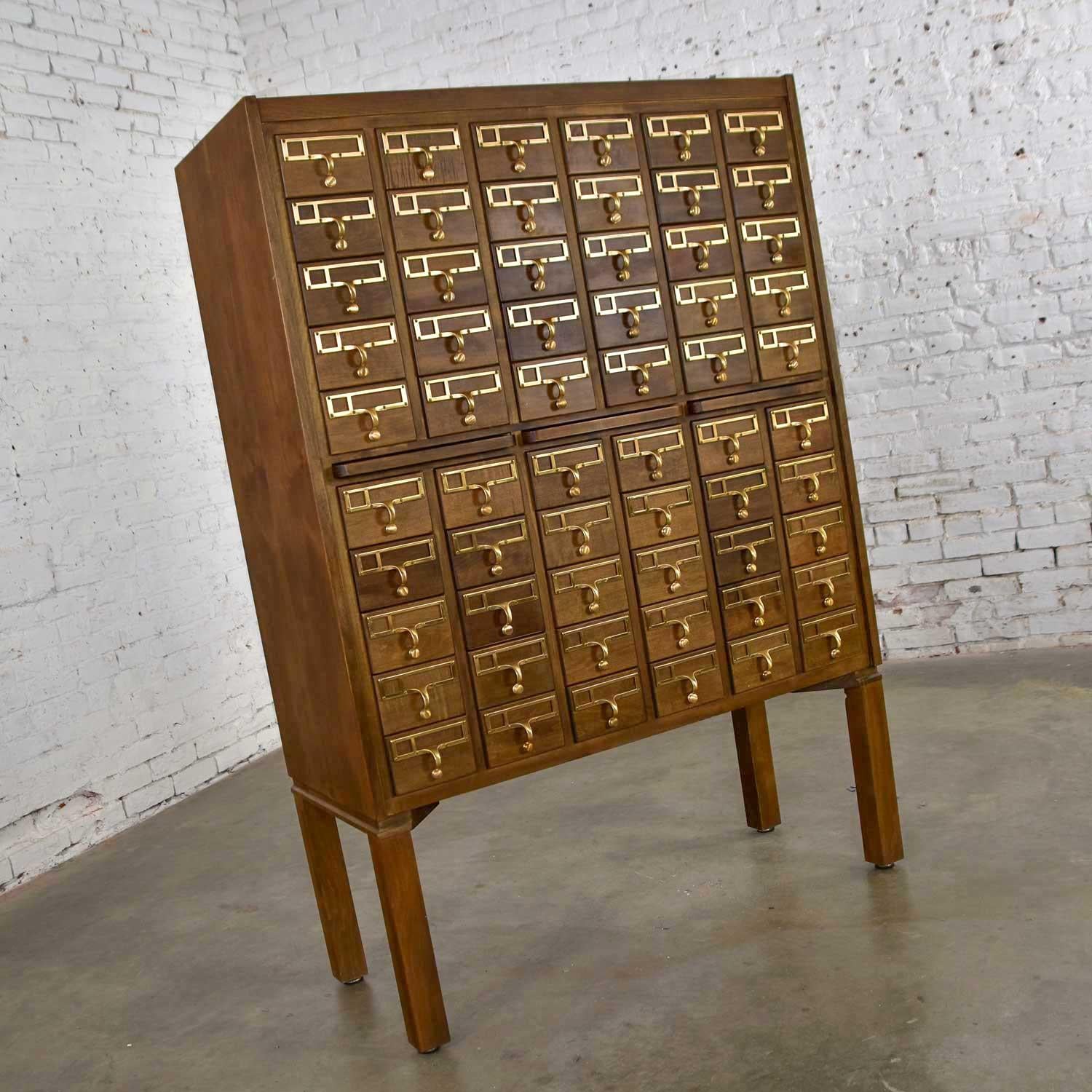 Incredible Mid-Century Modern vintage library card catalog comprised of walnut finished wood and 60 pull out compartments with cast bronze pulls. Excellent condition with minor signs of age and use. Please see photos, circa 1960s-1970s

Excuse