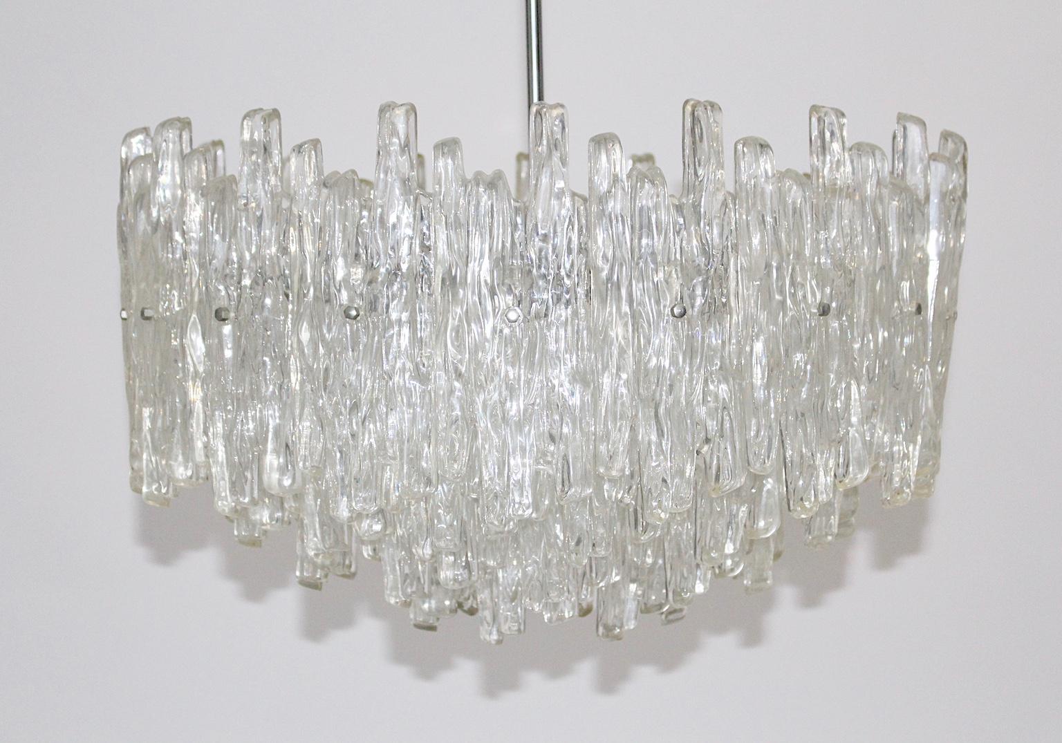  Mid-Century Modern vintage Lucite chandelier or pendant, which was designed and manufactured in Austria, 1960s.
While the lamp shade was made out of many Lucite pieces in organic form, a chromed stem and the details are made of nickel-plated and