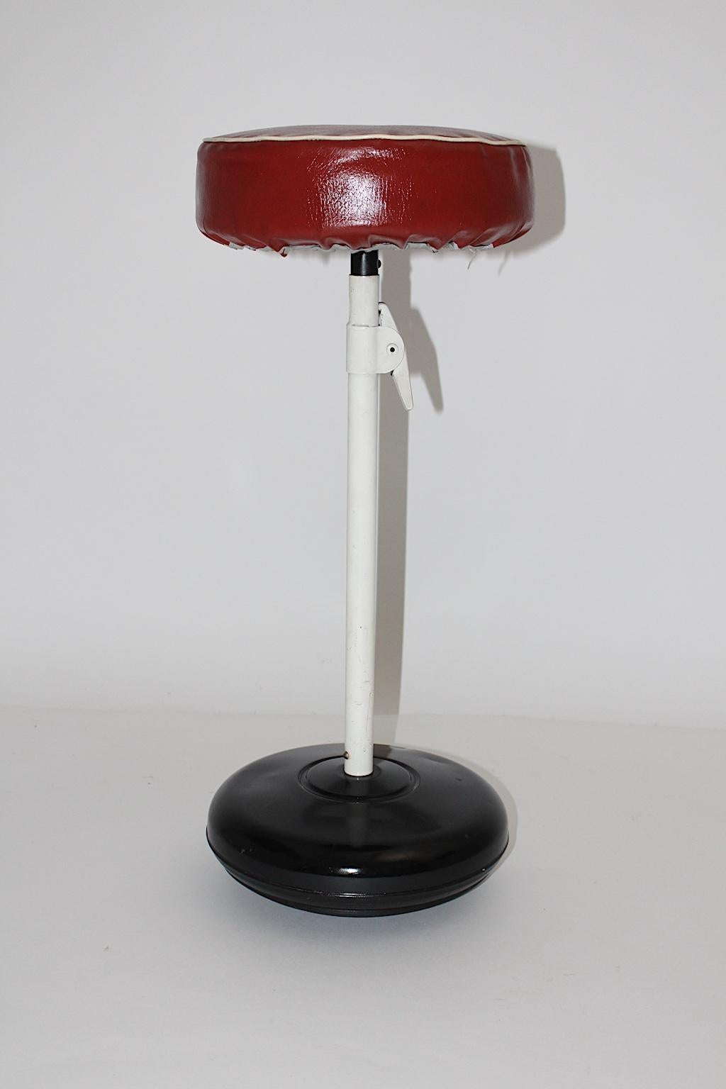 A Mid-Century Modern vintage black and white metal rocking stool, which was designed and made circa 1950s in Austria.
The seat was covered with red faux leather, while the round bottom was made of black rubber.
Also the stool has an adjustable