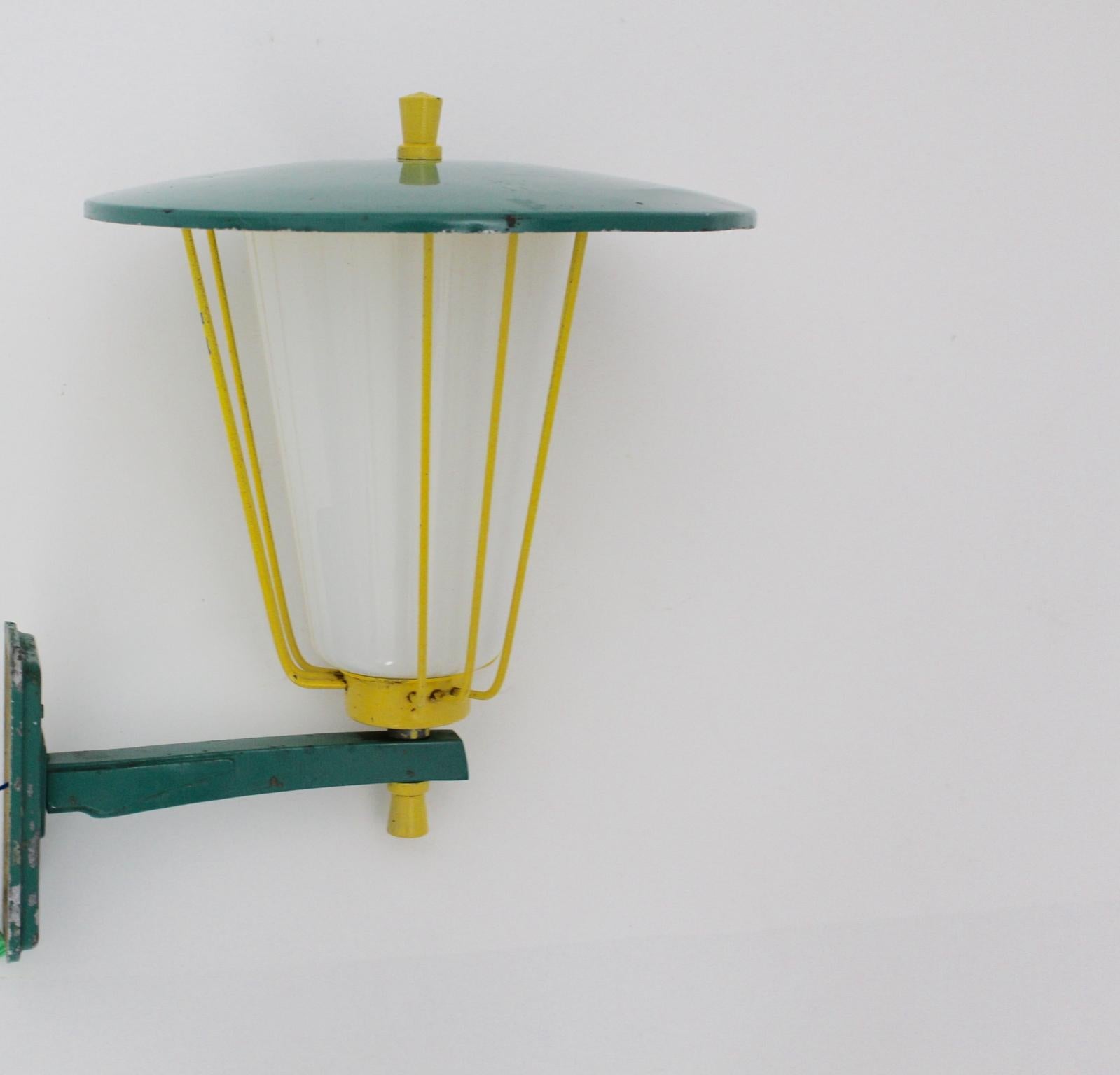 Mid Century Modern vintage wall light or sconce designed and executed by Kalmar, circa 1960, Vienna. The sconce was made of cast iron and metal, which is green and yellow lacquered. Also the sconce shows a white plexiglass shade and one E 27