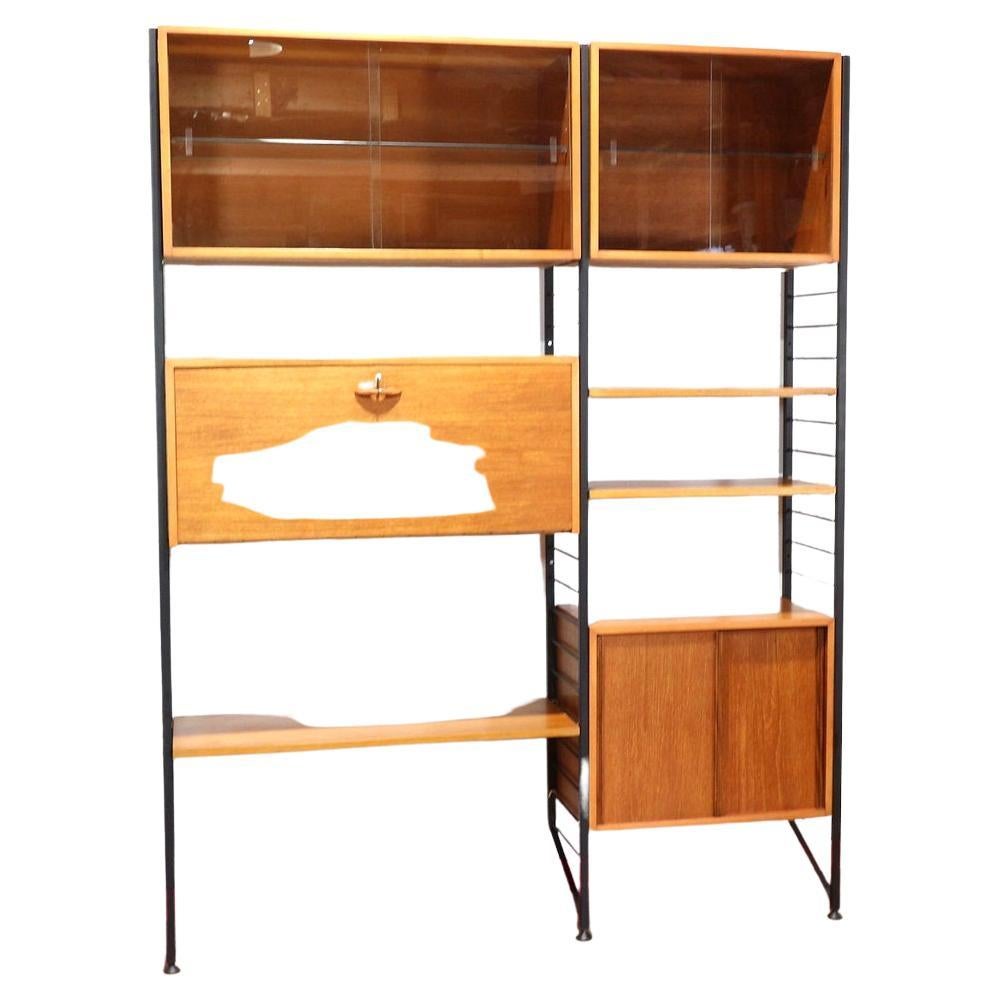 A stunning modular wall unit made by Ladderax as part of their Staples range. A universal piece of furniture that can be configured in many ways an made from golden teak veneer with metal uprights this cabinet is a real show stopper and offers great